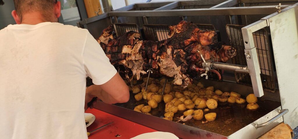 Mann bereitet gegrilltes Fleisch und Kartoffeln vor.