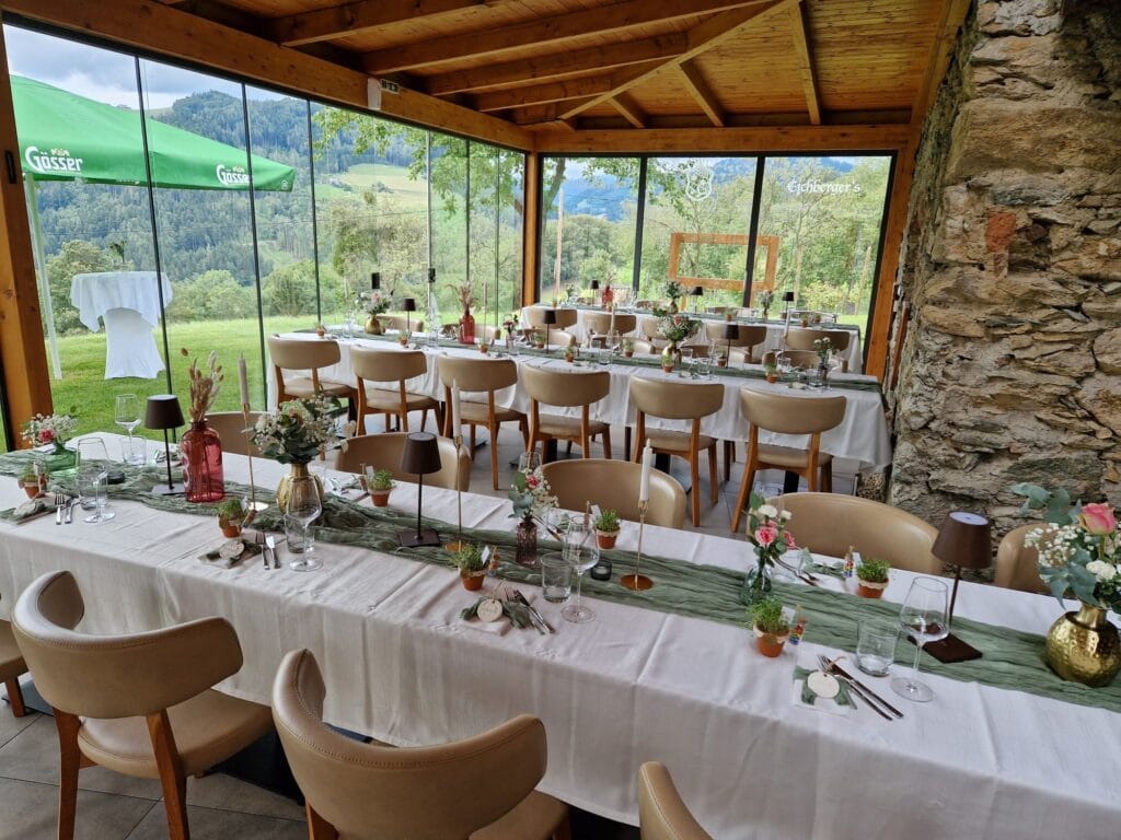 Hochzeitstisch im stilvollen Raum mit Panoramafenstern und Naturblick.