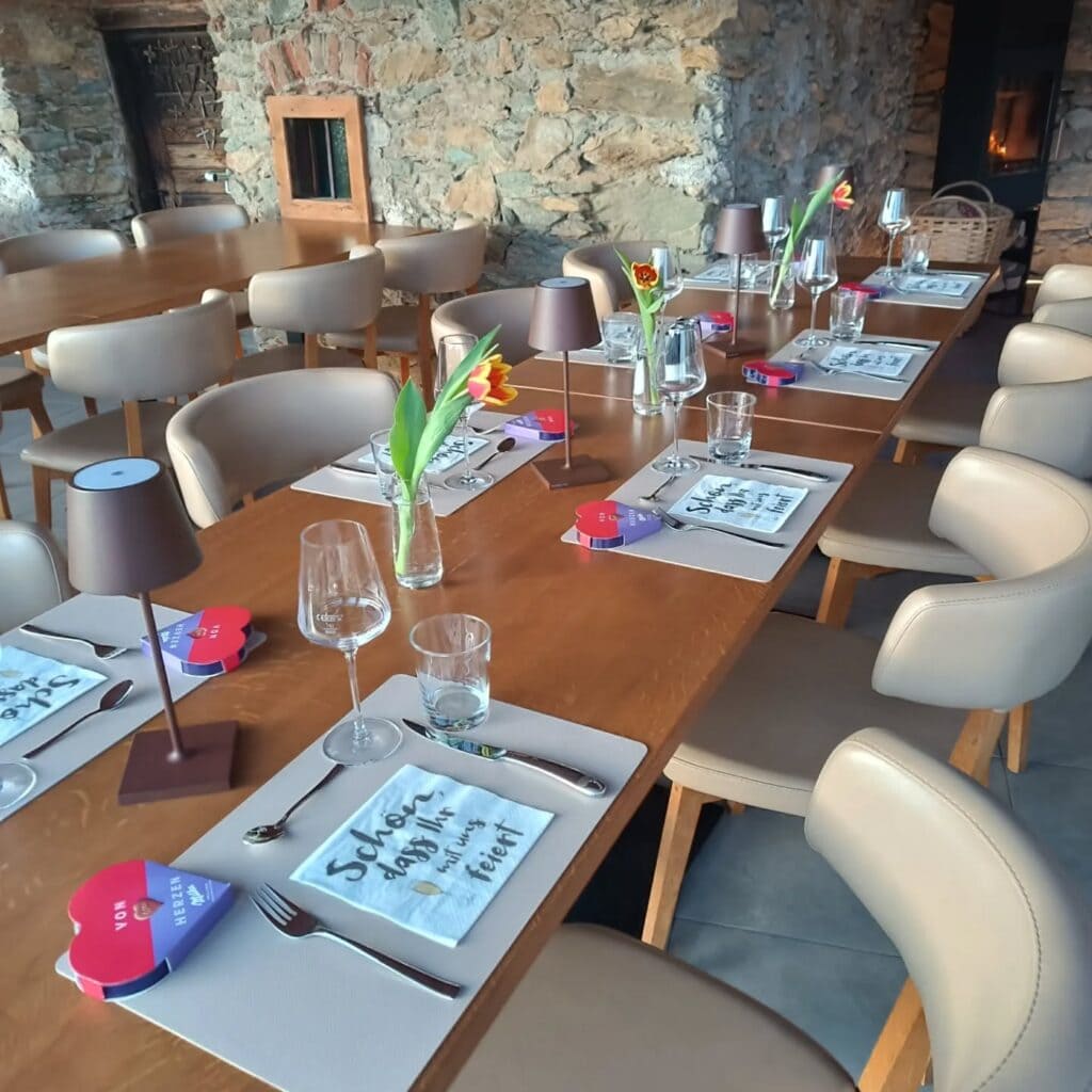 Stilvoller Veranstaltungsraum mit gedecktem Tisch und Blumenarrangement.