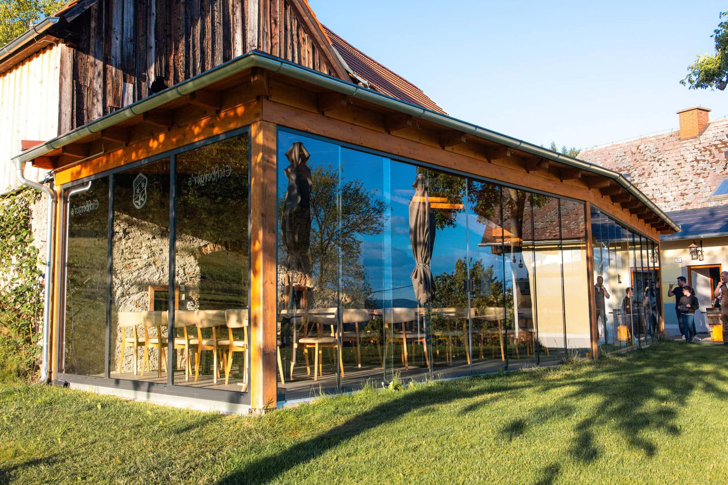 Modernes Grillrestaurant mit großen Glasfenstern und Gartenblick.