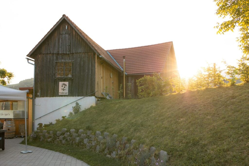 Altes Bauernhaus mit Sonnenlicht im Hintergrund, idyllische ländliche Szene.