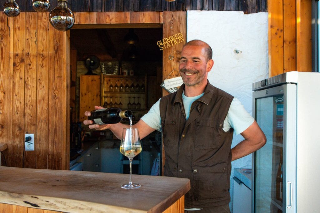 Mann serviert Wein bei einem Grill-Event in einer rustikalen Bar.